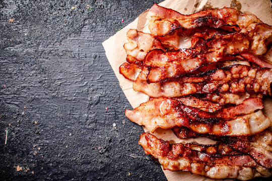 Pieces of fried bacon on paper. 