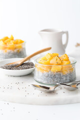 Homemade chia pudding parfaits topped with chopped mango, ready for eating.