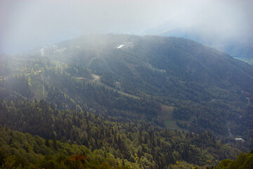 Obraz premium Mountain range with visible silhouettes through the morning colorful fog.