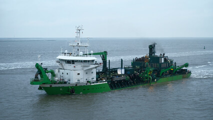 Elbe river, Germany - 01 20 2023: Belgian suction hopper dredger with forward wheelhouse powered by LNG during river maintenance © I am from Mykolayiv