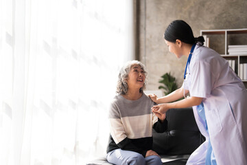 Fototapeta na wymiar Young caregiver helping senior woman walking. Nurse assisting her old woman patient at nursing home. Senior woman with walking stick being helped by nurse at home.