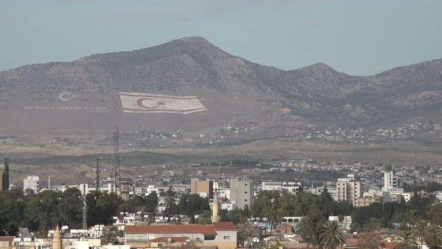 Massive flag of the (largely unrecognized) Turkish Republic of Northern Cyprus on the mountains behind Nicosia, the last divided capital city in Europe
