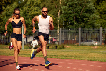 Fototapeta premium Woman and man jogging in the stadium