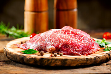 Raw meat on wooden table. Premium juicy Marble beef steak, Black Angus Steak Rib eye. Spices. On wooden plate. Close up image
