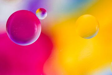 Oil drops in water and air bubbles, macro photo, selective focus. Bright multicolored background. gradient and copy space