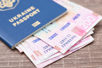 Biometric passport of ukrainian citizen with 200 hryvnias bills in it, close up. National currency concept, money and salary in Ukraine