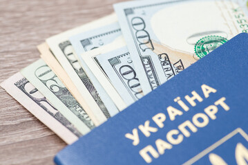 American 100 dollar banknotes inside of ukrainian biometric passport. Macro shot of US currency, work and travelling abroad concept
