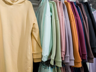 Pastel-colored sports hoodies on a hanger