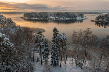 Soukka, Finland - 09.12.22: Top view of the snow-covered Soukka Islands in Espoo. Sunset on a winter day. There is ice on the water in places. Winter landscape. Scandinavia.