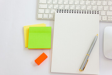 Notepad with a pen on a table with a keyboard