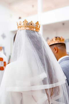 wedding of newlyweds in a Christian church. Golden wedding crowns on the head of the bride and groom
