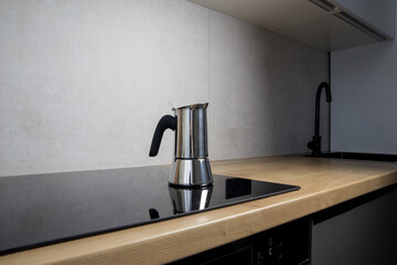 a geyser coffee machine brews at home on an induction stove