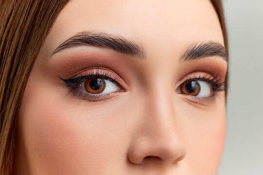 Cropped image of female eyes. Model with brown eyes and nude makeup. Eyebrow lamination. Eye care. Concept of natural beauty, skin care, cosmetology, cosmetics, health, medical care