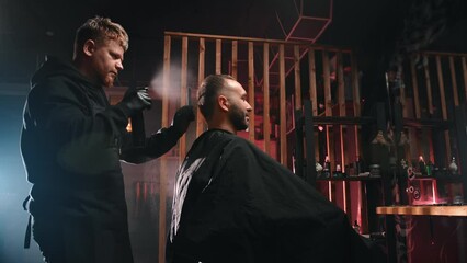 Male barber combing customer hair spraying water hairdo haircut styling at barbershop slowmo