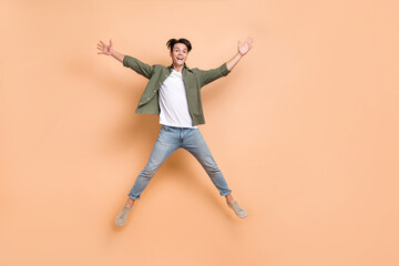 Fototapeta na wymiar Full body length size photo of youngster carefree jumper arms star symbol enjoy traveling flying overjoyed isolated on beige color background