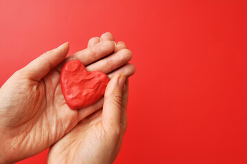 Plasticine heart in the hands. A symbol of love, conversation and declaration of love