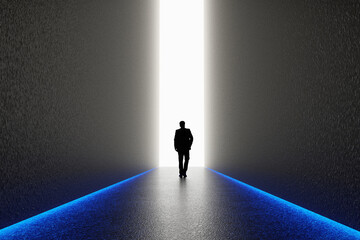 The silhouette of a man walking towards a bright light in the opened huge wall. A light in the end...