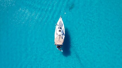 Top view of the white luxury wooden boat in coral sea blue water
