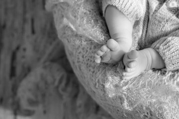 Closeup picture of newborn baby feet on knitted plaid