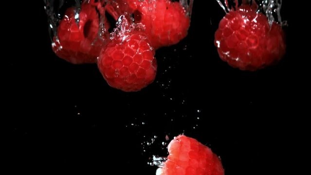 Fresh raspberries fall underwater with bubbles. Filmed is slow motion 1000 fps. High quality FullHD footage