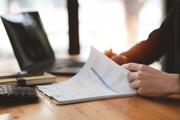 Business man pointing to a pie chart document showing company financial information, He sits in her...