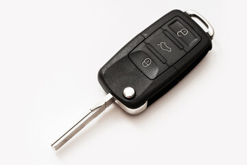A macro photo of a black car key on a white background