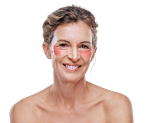 A mature woman wearing under-eye gel patches while posing against isolated on a transparent PNG background