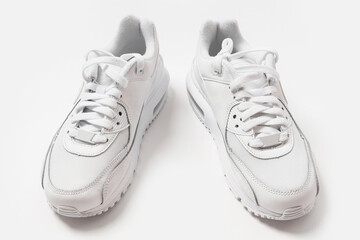 White leather trainers with a shadow on white background
