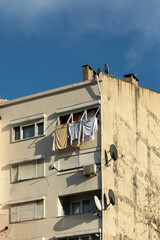 Fototapeta na wymiar Typical residential building. Laundry is being dried on the balcony.