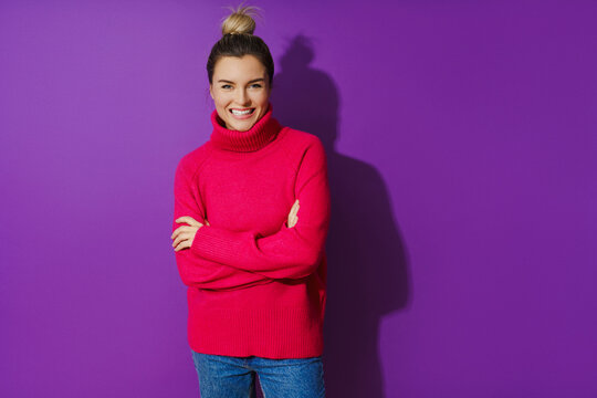Young woman wearing warm and cozy polo neck sweater against purple background
