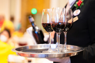 Wine glasses in a tray ready to be served by staff serving at a party in a luxury hotel