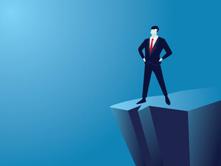 Strong confidence businessman standing by the edge of cliffwith hands oh hips, ambition and determination in business concept