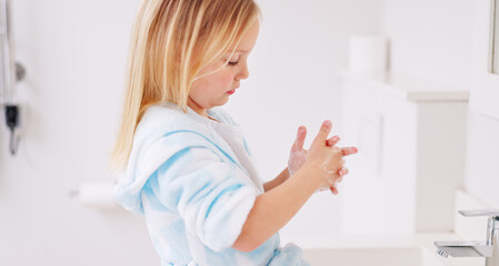 Girl washing her hands in the bathroom of her home for hygiene, stop germs and prevent bacteria. Healthcare, clean and young child doing sanitary routine with soap and water in the basin at her house