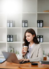 Working woman concept a female manager attending video conference and holding tablet, smatrphone and  cup of coffee