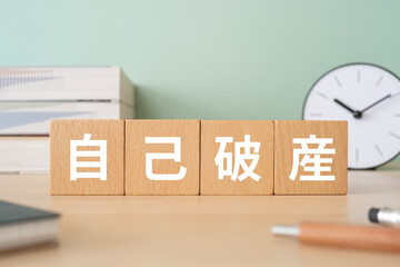 自己破産と書かれたブロックが置かれたデスク