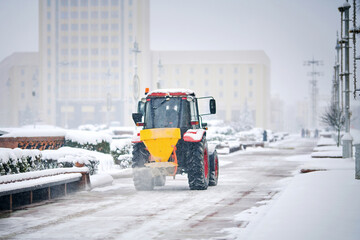 Tractor with salt bucket spread salt, deicing street. Utility service melt ice. Tactor spreading...