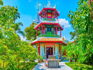 Amazing colorful Chinese shrine Chao Mae Takhian Thong and high chedi of Wat Ratchapradit on background, Bangkok, Thailand