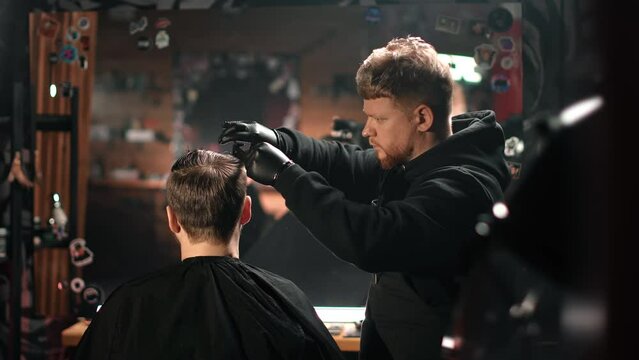Skilled male barber cutting customer hair use scissors hairstyle hairdo vintage barbershop interior