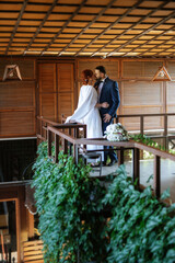 Fototapeta premium bride in a white dress with a bouquet and the groom in a blue suit