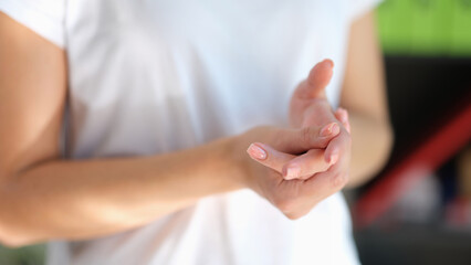 Close-up of woman applying cream to her hand.