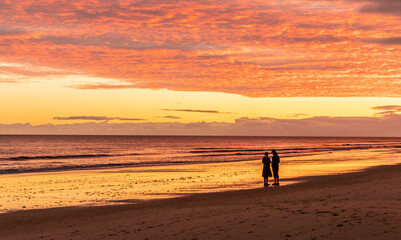 Fototapeta na wymiar sunset beach with couple silhouette Wallpaper