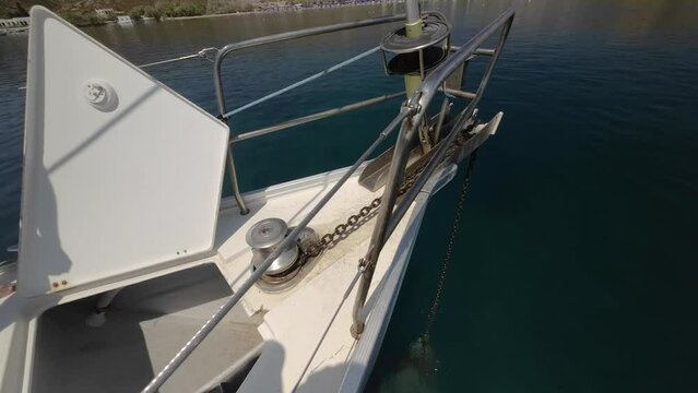 Close-up of the anchor chain retracting on a yacht. Raising the anchor on a yacht, a winch unwinds an iron chain with an anchor, a marked chain waiting for the anchor to be raised