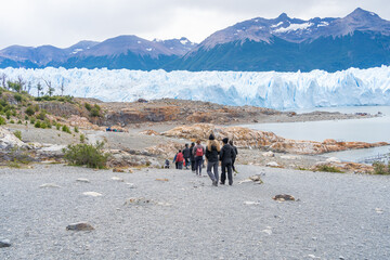 Las personas van por el camino de tierra hacia el glaciar Perito Moreno para realizar el mini trekking.
