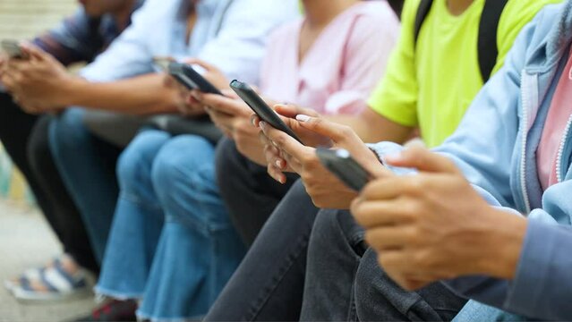 close up shot, hands of Group of indian college students busy on mobile phone at campus during leisure - concept of social media sharing, cyberspace and internet addiction.