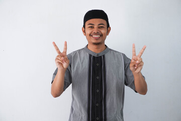 smiling or happy young asian muslim man showing pointing up with fingers number two while confident...