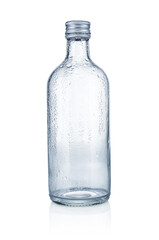Empty glass bottle with water drops on white background