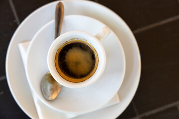 Top view of a black coffee in a white cup and saucer