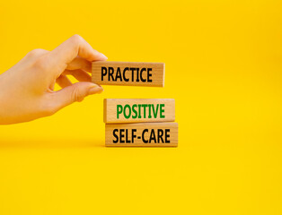 Practice Positive Self-care symbol. Concept words Practice Positive Self-care on wooden blocks. Businessman hand. Beautiful yellow background. Business concept. Copy space