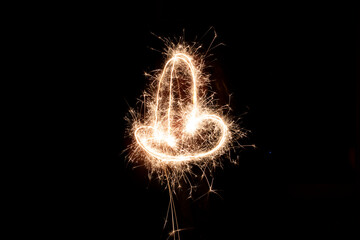 Different figures, letters or drawings created at night with flares; infinity symbol, a heart, cross or different letters
