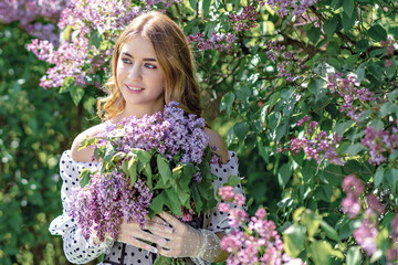 Portrait of a smiling young girl in blooming lilac trees. Summer time,vacation